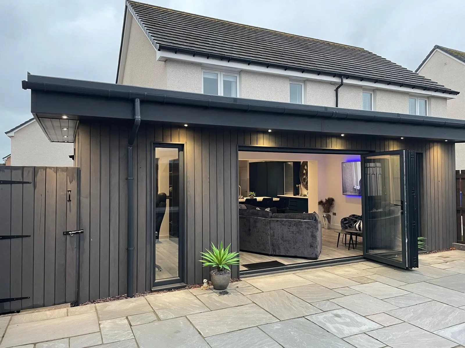 Dark-clad rear extension with bifold doors open to the patio in Cardiff — All Aspects Construction